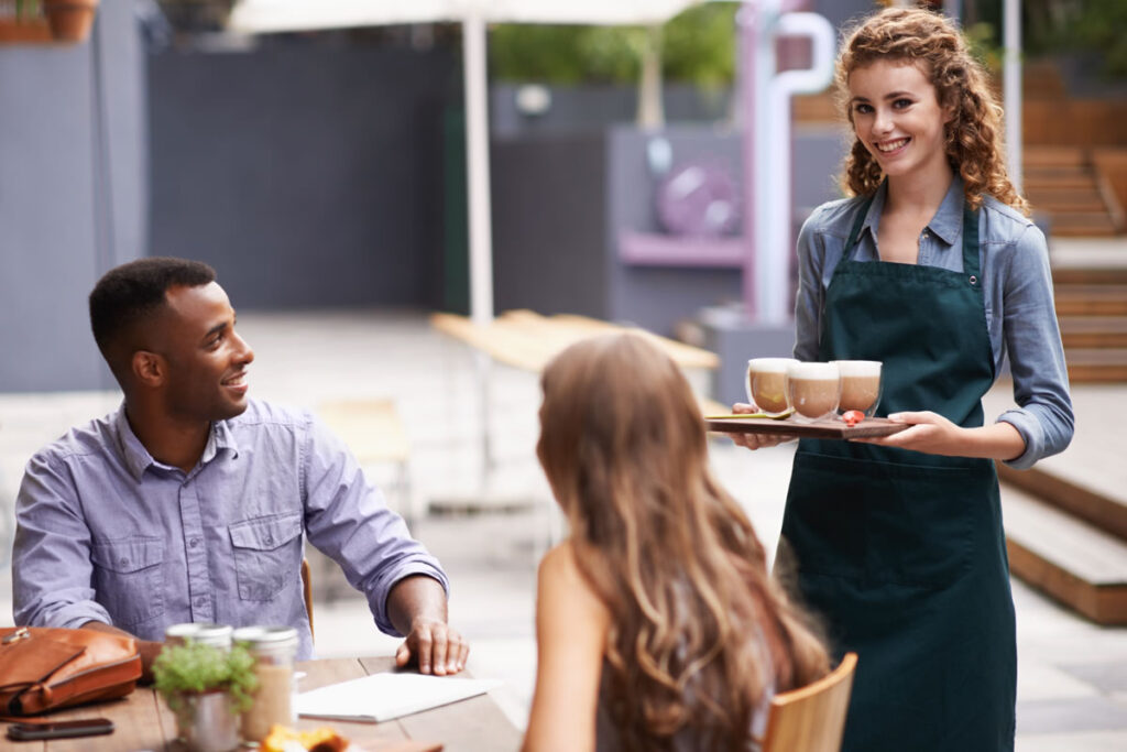 Female law student working as waitress serving coffee to friends