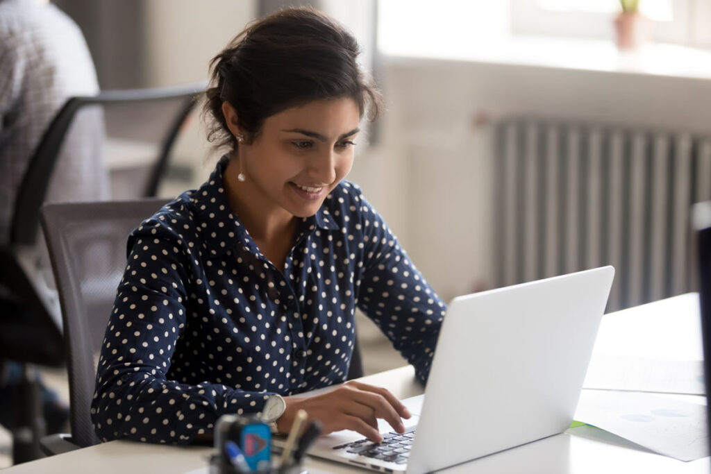 Young lawyer working on a laptop to develop the legal, regulatory and technology skills needed for a future career in AI governance law.